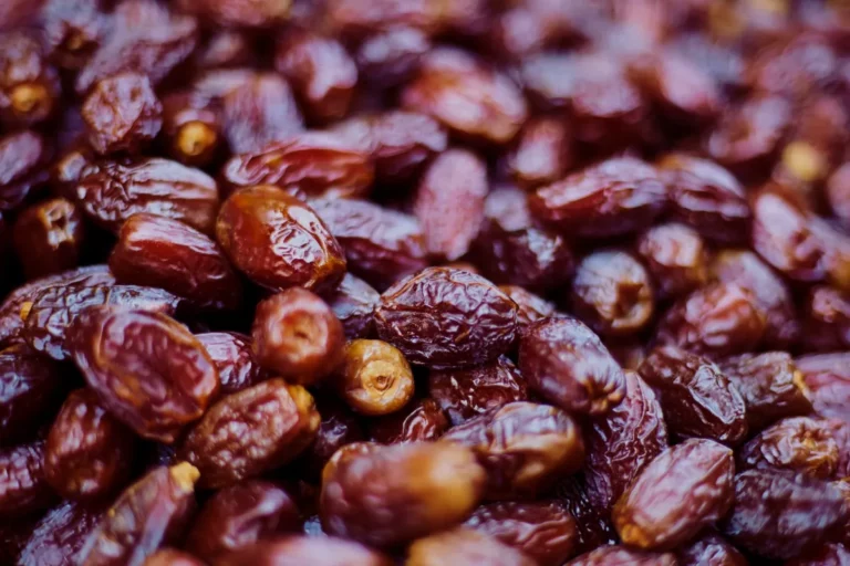 Dattes Ajwa de Médine : fruits mûrs à peau foncée et ridée, disposés sur un plateau en bois naturel